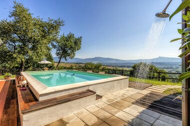 Ferienhaus mit Pool in der Toskana, Gäste entspannen am Pool mit Blick auf die hügelige Landschaft.
