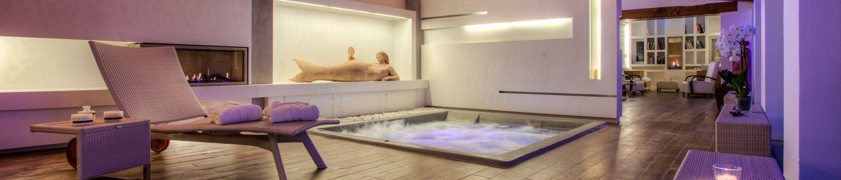 Luxuriöser Wellness-Bereich mit Relaxliege und Kaminfeuer in einem Toskana Ferienhaus